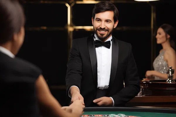 A woman in a luxurious green gown next to an ornate roulette wheel, capturing the upscale casino mood of 4777BE5.