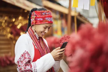 A woman smiling by bright slot machines showing lucky symbols, showcasing the exciting slot offerings at 4777BE5.